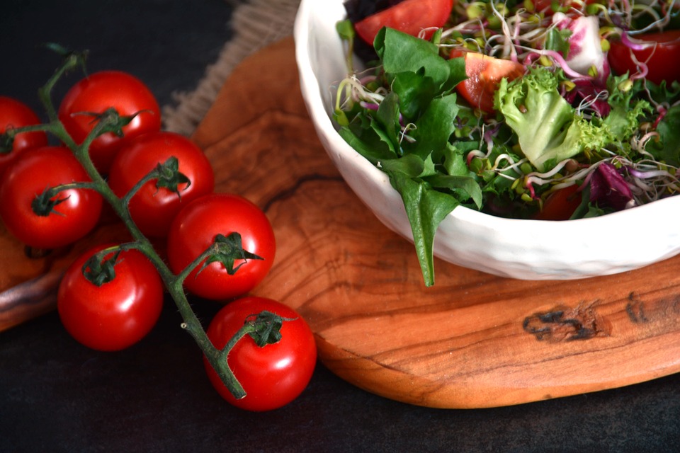 a bowl of salad and some cherry tomatos